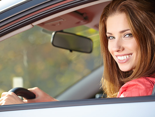 Car Insurance for Matthews, NC, with Woman Smiling in her Insured Auto