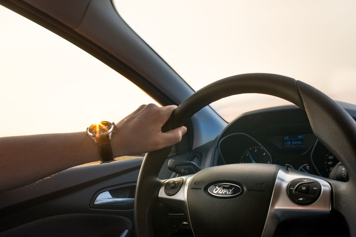 A hand on the steering of a car with Auto Insurance in Matthews, NC, Charlotte, Fort Mills, SC, Concord, NC, and Surrounding Areas